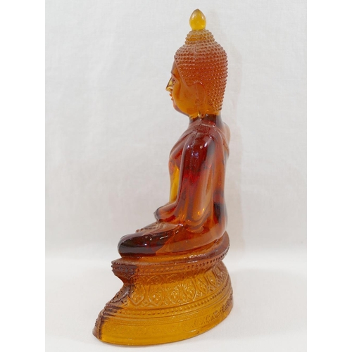 14 - An amber glass seated Buddha, the hollow moulded glass figure depicted in the lotus position with ha... 