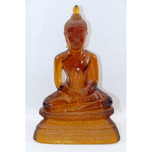 14 - An amber glass seated Buddha, the hollow moulded glass figure depicted in the lotus position with ha... 