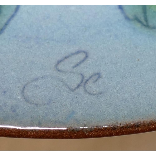 43 - A 20th century Chelsea Pottery dish, hand decorated in enamels on a blue ground with a bee, apples, ... 