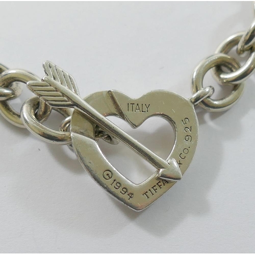 162 - A heavy silver coloured metal necklace with heart and arrow interlocking clasp, stamped 'Tiffany & C... 