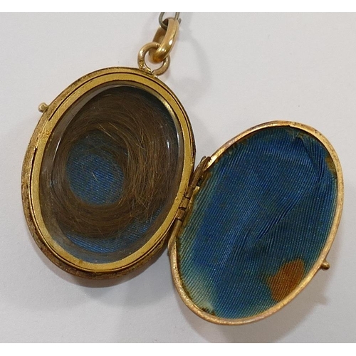 171 - A 19th century French gold oval locket, set with single red stone within inlaid black enamel surroun... 