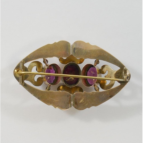 195 - A Victorian hollow gold garnet set brooch, the three oval mixed cut almandine garnets centrally set ... 