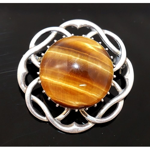 201 - Four items of tiger's eye jewellery comprised of a large single stone ring, a circular openwork broo... 