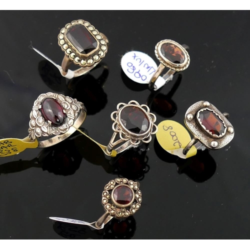 215 - A collection of 12 red garnet set rings, including some set with marcasite, most stamped 'silver' or... 