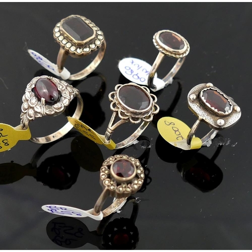 215 - A collection of 12 red garnet set rings, including some set with marcasite, most stamped 'silver' or... 