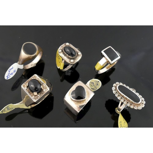 220 - A collection of 12 black onyx set rings, most stamped 'silver' or '925', including a range of sizes ... 