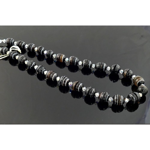 241 - A selection of striped onyx jewellery comprised of a graduated bead necklace with paste dividers, 12... 