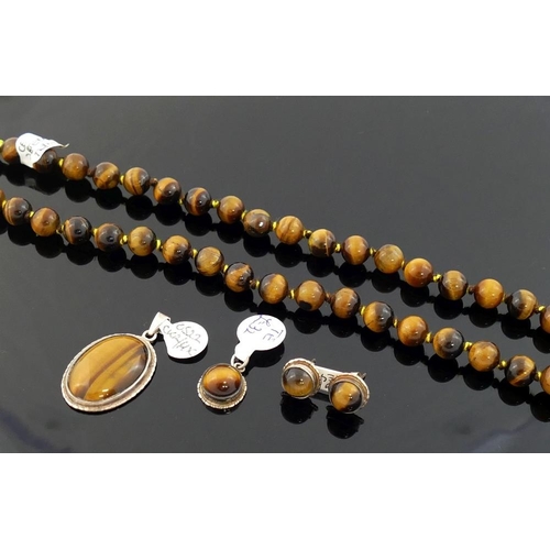 275 - A selection of tiger's eye jewellery comprised of a string of cylindrical beads, a round cabochon su... 