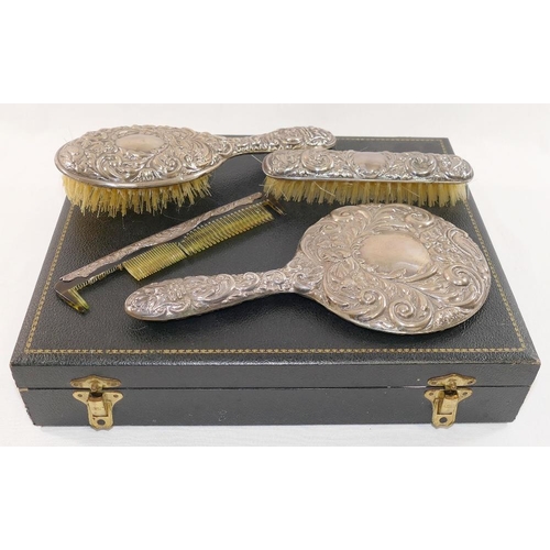 312 - A four piece silver backed dressing table set, comprised of a hand mirror, two brushes and a comb,  ... 