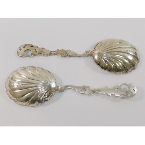 323 - A pair of late Victorian silver serving spoons with shell-shaped bowls and pierced and cast acanthus... 