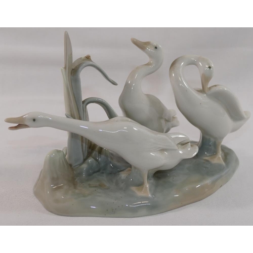 357 - A Lomonosov USSR porcelain giraffe in seated position, 26cm long, and a Lladro porcelain geese group... 