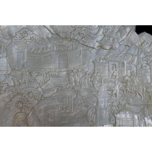 371 - A large Chinese carved mother of pearl shell intricately decorated with a battle scene amongst build... 