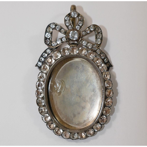 168 - A large 19th century paste set silver locket, with hinged back and bow surmount, 7.5cm long x 4.2cm ... 