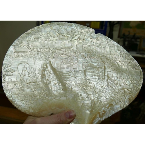 371 - A large Chinese carved mother of pearl shell intricately decorated with a battle scene amongst build... 