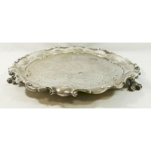 104 - A large Victorian circular silver tray, London 1879, with ornate scroll rim, raised on four scroll f... 