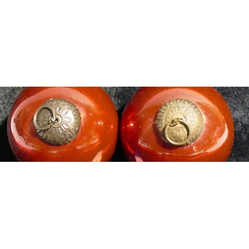 139 - A pair of glass witches balls, with red interiors, fitted with moulded metal mounts, 10cm diameter