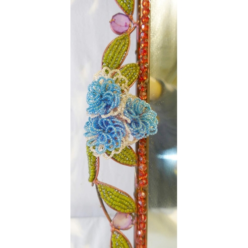 183 - A vintage rectangular mirror with floral and foliate beaded surround, mounted to steel wire and fram... 