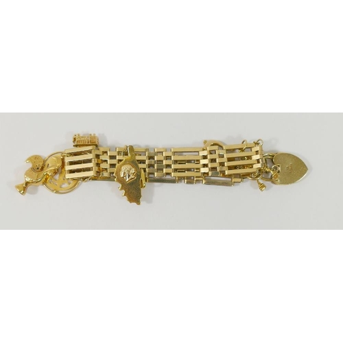 2A - A 9 carat gold gatelink bracelet, London 1978, hung with six yellow metal charms, various purities, ... 