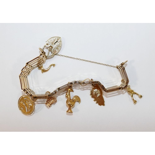 2A - A 9 carat gold gatelink bracelet, London 1978, hung with six yellow metal charms, various purities, ... 