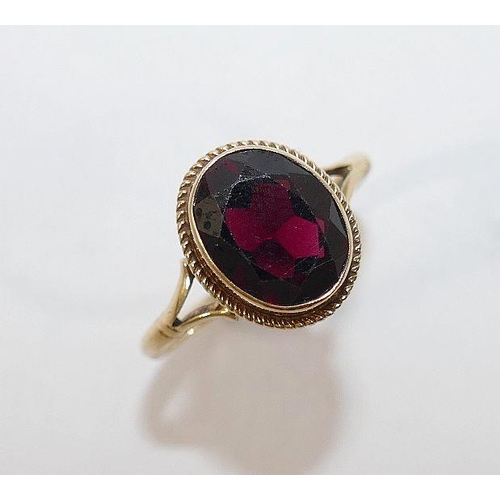 21 - A 9 carat gold single stone garnet ring, and a pair of 9 carat gold stud earrings of similar design,... 