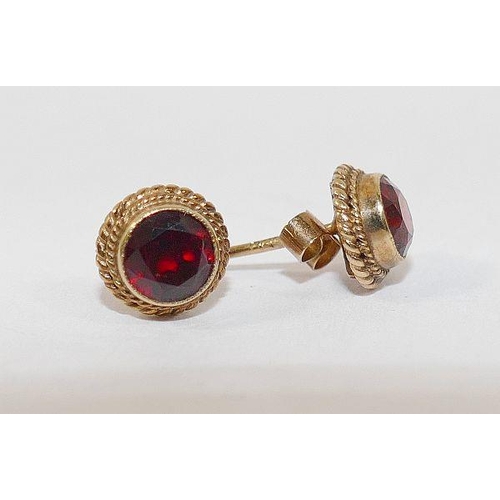 21 - A 9 carat gold single stone garnet ring, and a pair of 9 carat gold stud earrings of similar design,... 