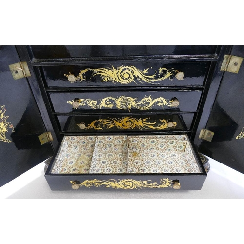 213 - A Victorian papier maché table top cabinet, inlaid with mother of pearl and decorated in gilt, the h... 