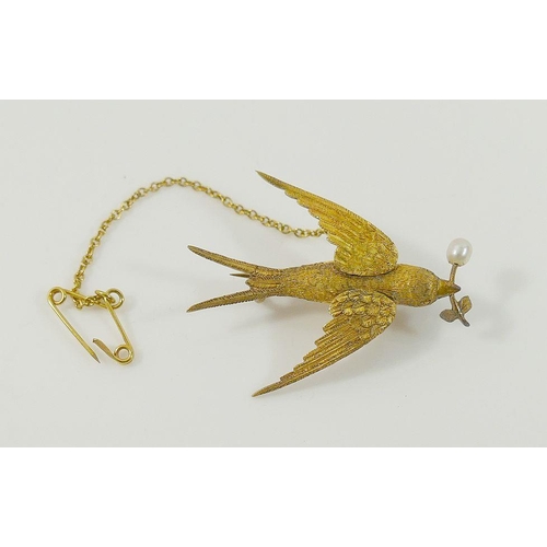 26A - A Victorian hollow gold brooch in the form of a swallow carrying a branch, set with small single pea... 