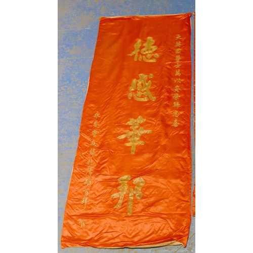 280A - A Chinese silk drape with gilt thread embroidered lettering, 180cm x 70cm, and another red silk wall... 