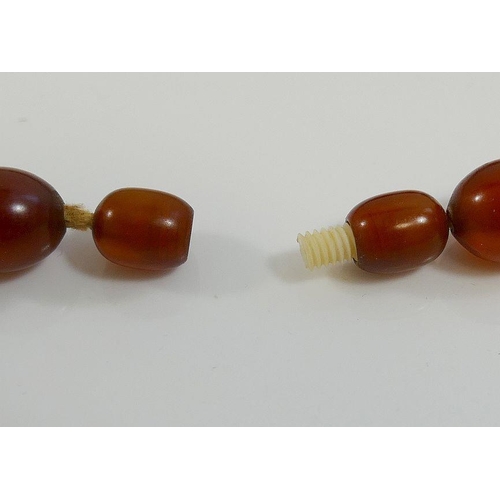 41A - A string of graduated amber coloured beads, possibly Faturan, 63cm long, 61g gross, and a collection... 