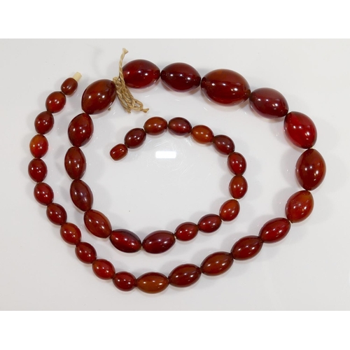 41A - A string of graduated amber coloured beads, possibly Faturan, 63cm long, 61g gross, and a collection... 