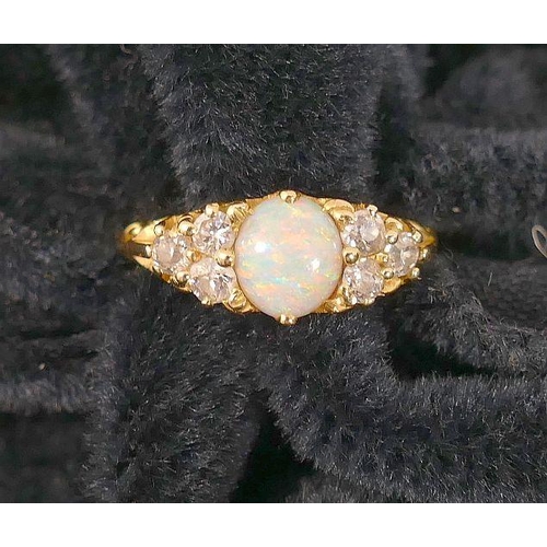 64 - An early 20th century 18 carat gold opal and diamond ring, the oval opal cabochon 7mm x 6mm x 3mm de... 