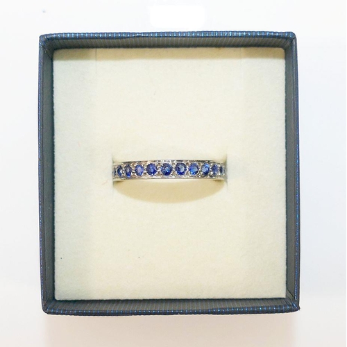 7A - A sapphire eternity ring, set in unmarked white metal, finger size N1/2 3.6g gross