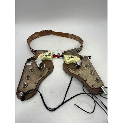 A vintage toy cap gun set with a double leather holster and matching ...