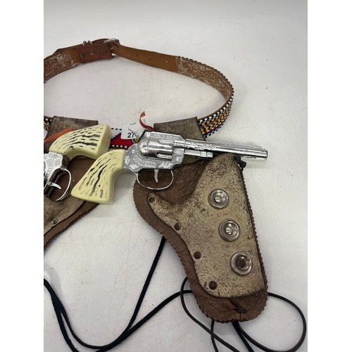 A vintage toy cap gun set with a double leather holster and matching ...