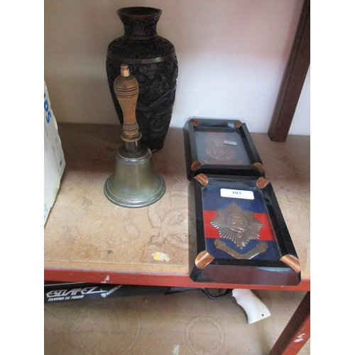 103 - A profusely carved oriental vase, a hand bell and two ashtrays each with military insignia