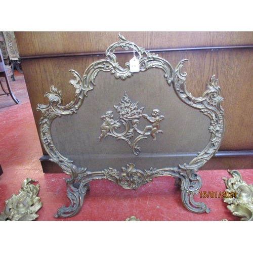 178 - A highly ornate gilt metal fire screen together with a similar fender