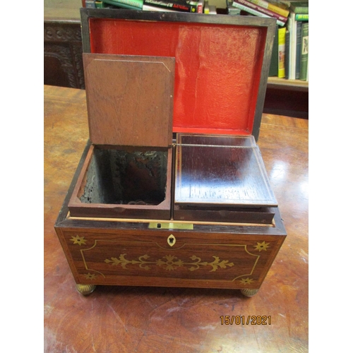 257 - A Regency brass inlaid rosewood rectangular tea casket containing two lidded caddies