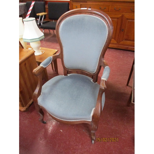 229 - A vintage mahogany spoon back open armchair upholstered in blue coloured fabric