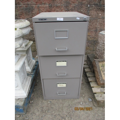 33 - A three drawer metallic filing cabinet