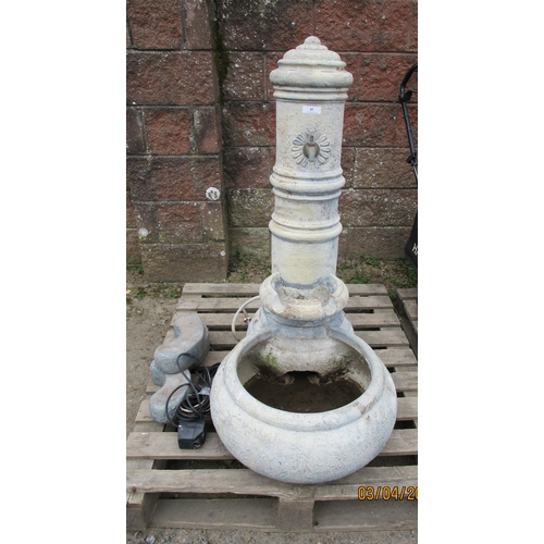 41 - A reconstituted stone garden water feature modelled in the form of a cast iron pillar fitted a tap