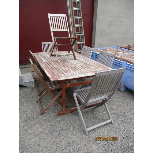 63 - A teak extending rectangular patio table together with seven matching folding chairs