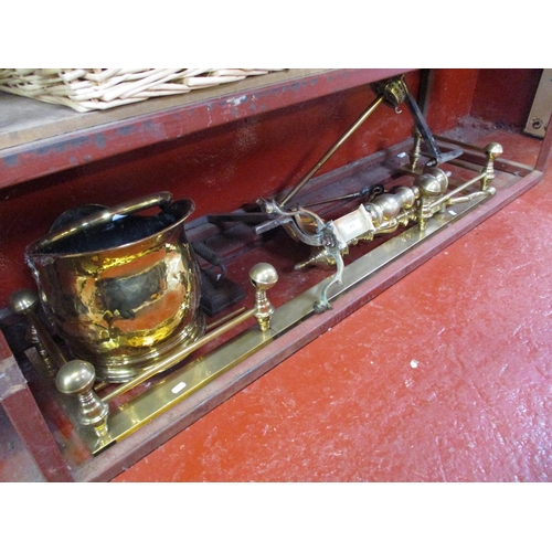 412 - A brass fire fender, fire dogs, coal scuttle, companion set and a flat iron