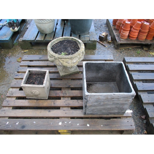 61 - A reconstituted stone stemmed garden urn together with two planters