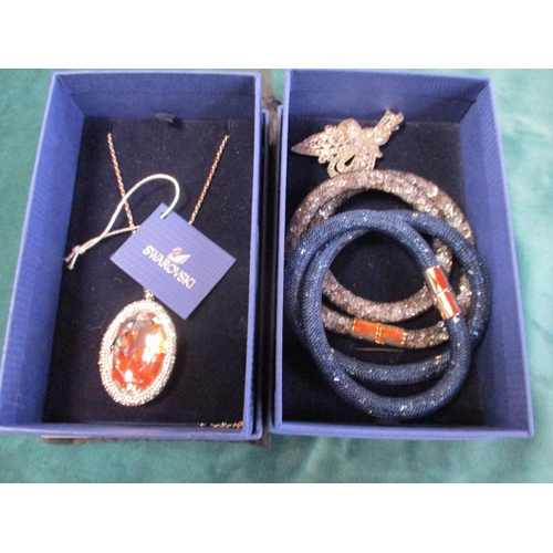 112 - A Swarovski necklace, two Swarovski bracelets together with a brooch