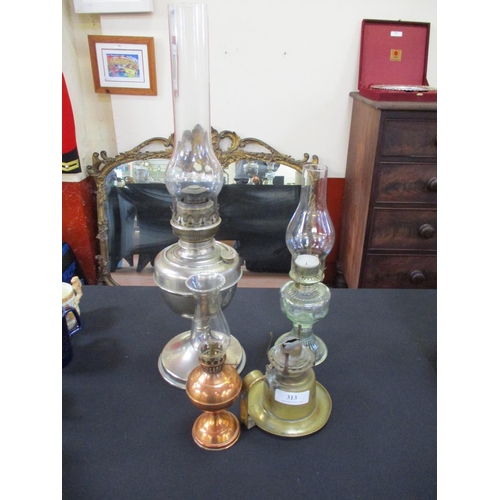 313 - Three paraffin oil lamps together with a brass paraffin chamber oil lamp