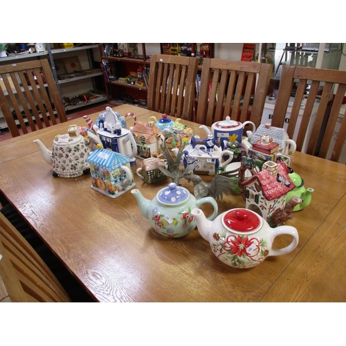 274 - A quantity of novelty teapots together with two metallic fighting cockerels