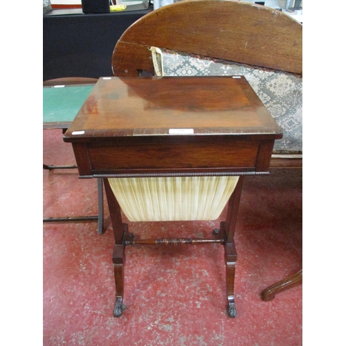 329 - A mahogany sewing table with brass paw feet