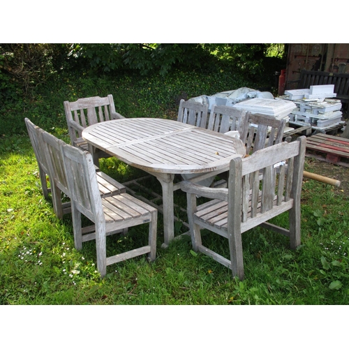 39 - A teak extending patio table together with two carvers, six chairs and a parasol