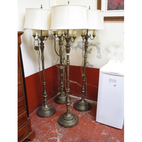 296 - A set of four gilded four branch lamp standards