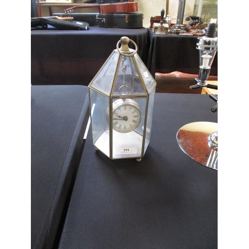 291 - A table clock modelled in the form of a gigantic pocket watch suspended within a hexagonal glazed ca... 